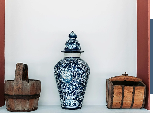 A blue and white vase sits on a shelf, ready to be discovered on an estate sale website.