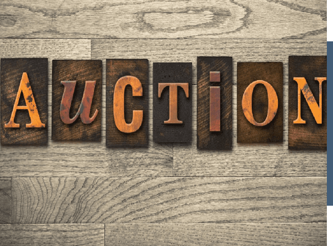 The word estate auction is spelled out on a wooden background.